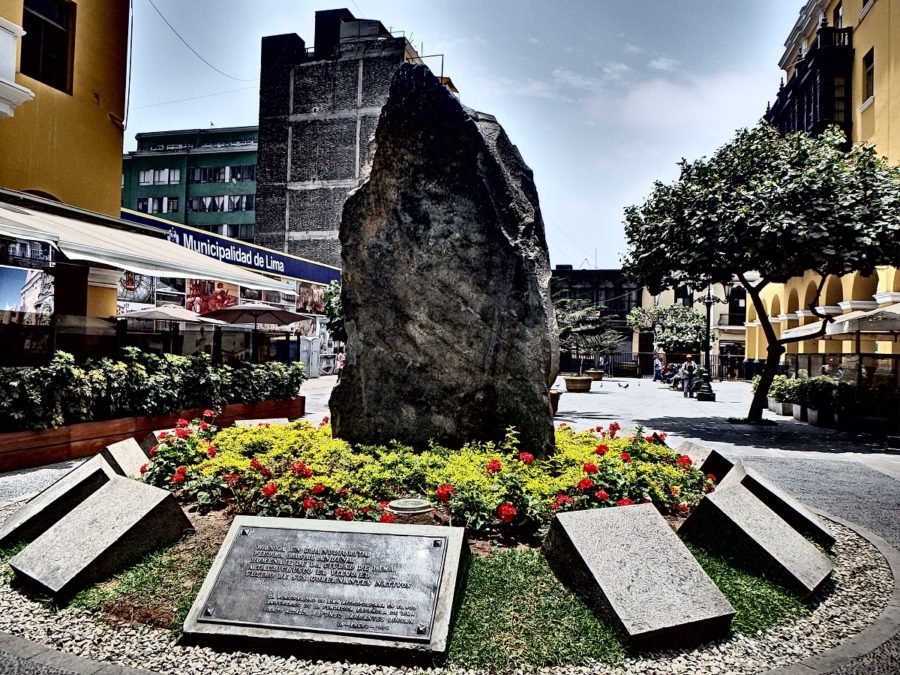 An 8ft stone encircled by flowers and plaques dipicting its history