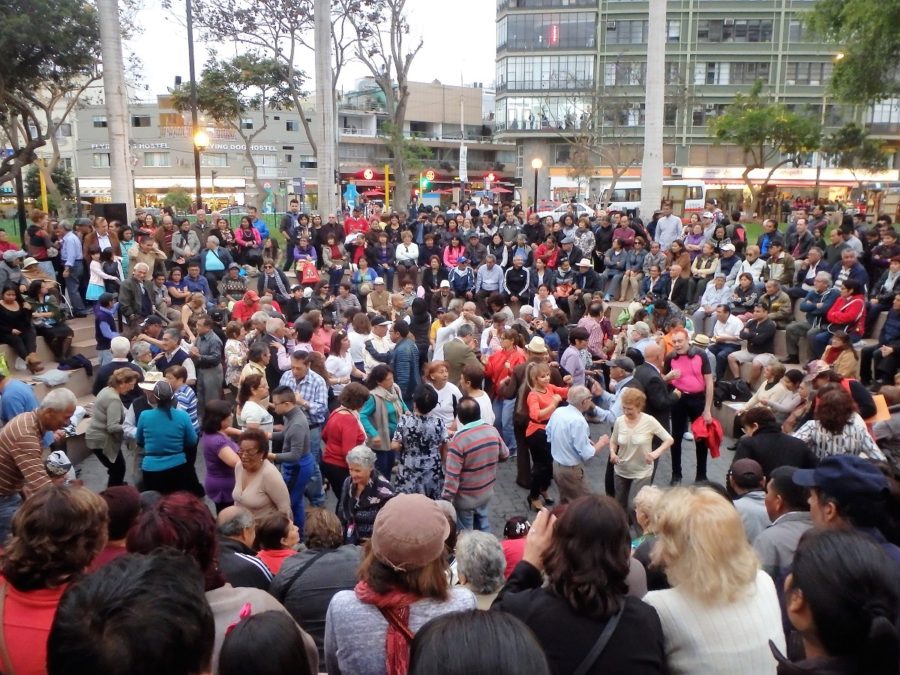 Hundreds of people crammed in a small ampitheatre dancing