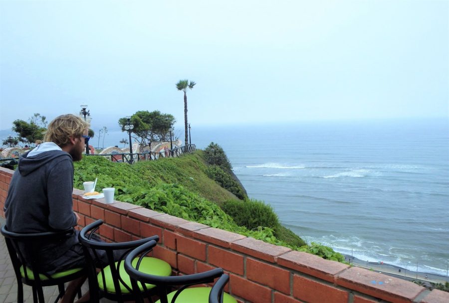 Rhys sat facing over the cliffs toward the ocean with an empanada and coffee