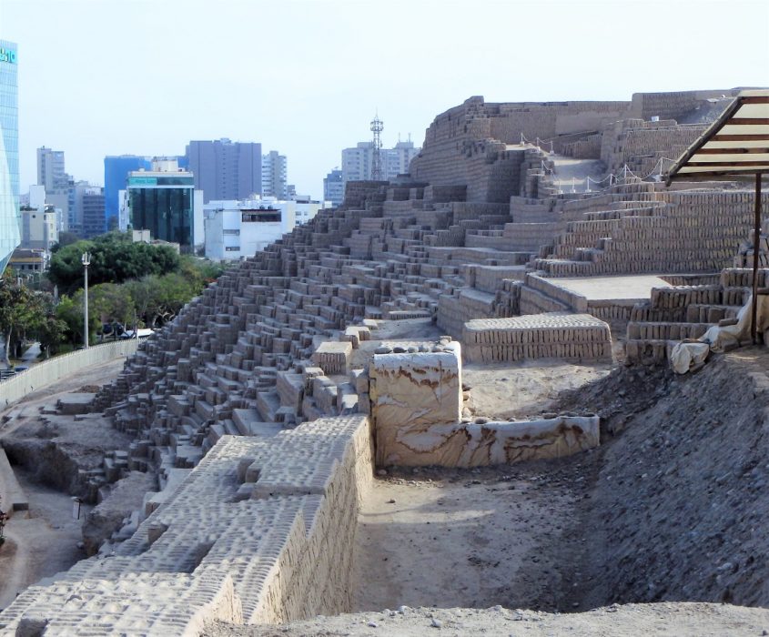 The pyramid-shaped side of Huaca Pucllana with Lima in the background