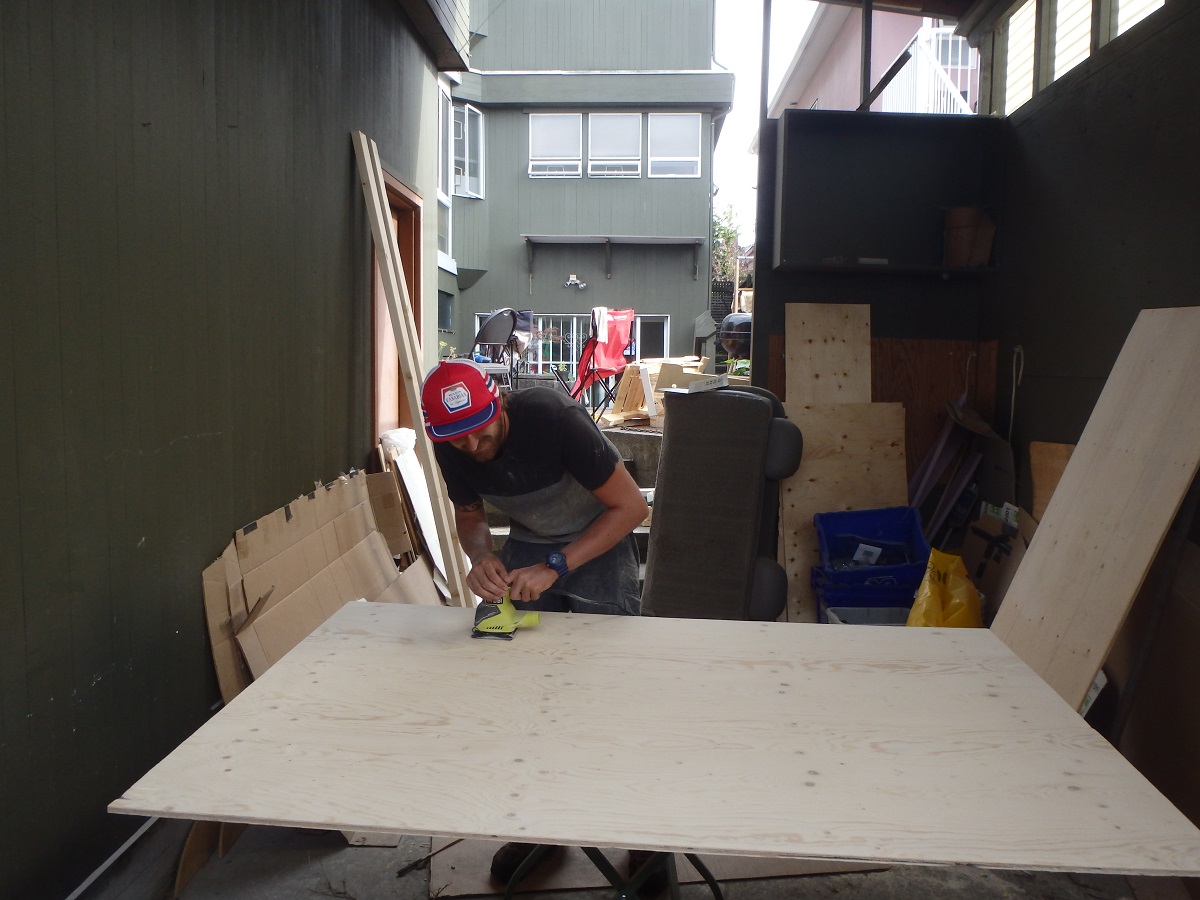 Rhys sanding plywood for the campervan interior