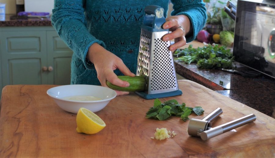 An image of me grating cucumber for the tzatziki.