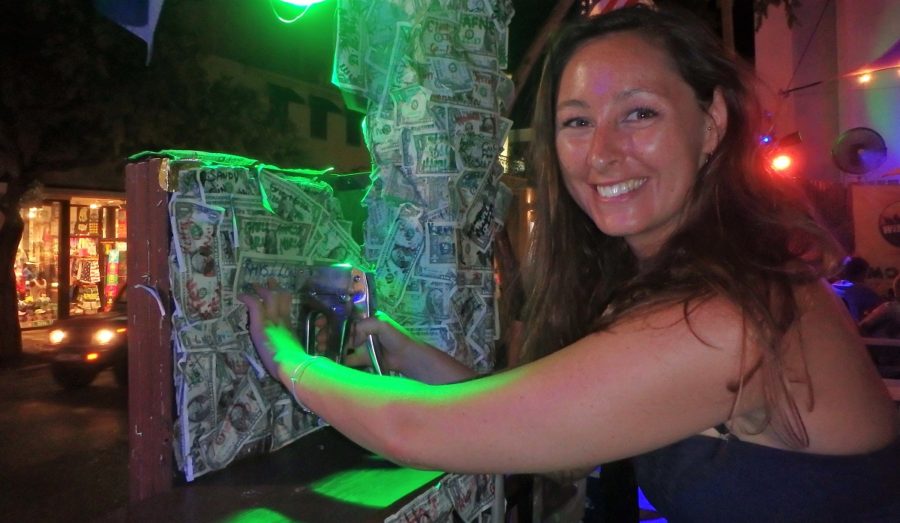 Lowri stapling a branded dollar bill to the wall in Willie T's in Key West